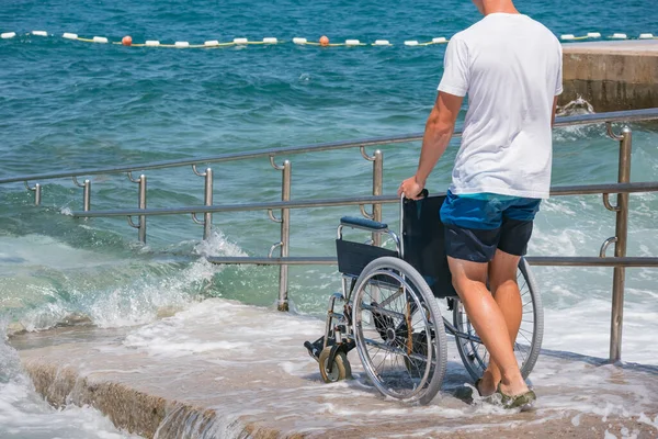 Accessible beach with wheelchair with ramp for persons with disability