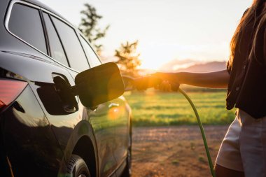 Sürdürülebilir kaynaklardan üretilen yeşil yenilenebilir enerji ve eko gücü kavramında elektrikli araba şarj istasyonu.