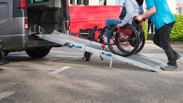 介助者の助けを借りて交通手段を利用して障害のある車椅子の方 — ストック写真