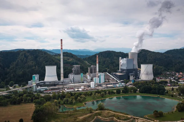 stock image Smoking chimney at thermal power plant near lake and green nature. Aerial view