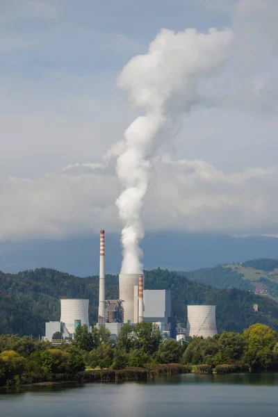 stock image Smoking chimney at thermal power plant near lake and green nature.