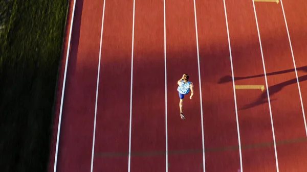 白人男子短跑运动员独自跑在田径运动跑道上 起跑位置和跑在第四行 空中高射 — 图库照片