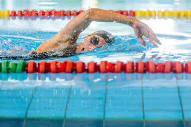 Professional female swimmer swimming the front crawl stroke. Freestyle competition concept. clipart