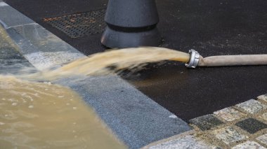 Şiddetli yağmur ve fırtınalardan sonra sel basmış caddeye su pompalamak