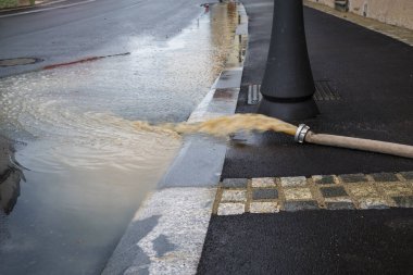 Şiddetli yağmurdan sonra şehir sokaklarında su pompası. Şiddetli hava felaketi.