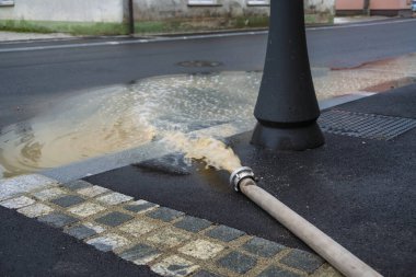 Şiddetli yağmurdan sonra şehir sokaklarında su pompası. Şiddetli hava felaketi.