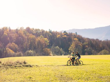 Eğlence amaçlı bisiklet süren çiftler kırsal alanda bisiklet sürerken manzaranın tadını çıkarıyorlar. Doğa, turizm ve aktif tatil kavramları.