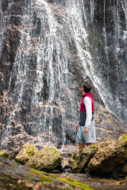 Görkemli şelaledeki insan ve kucaklayan doğa güzelliğinin tadını çıkarıyor. Seyahat ve macera kavramları.