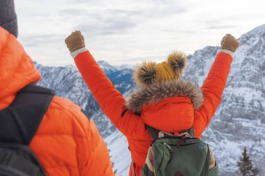 Yürüyüşçüler kışın dağın zirvesine ulaşmanın başarısını kutluyorlar.
