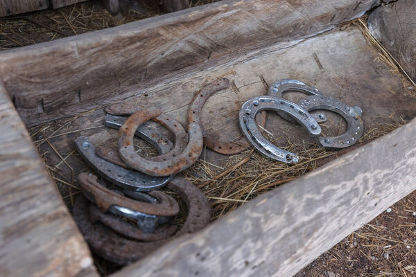 Старые и новые подковы на деревянном фоне.