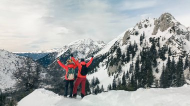 Dağcı çift, bir dağın tepesinden, hava manzarasından inanılmaz karlı manzaranın tadını çıkarırlar.