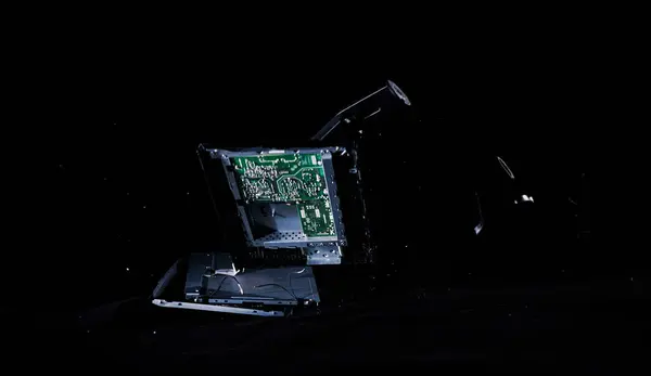 Throwing and breaking a computer screen into pieces to a hard surface, isolated on a black background, slow motion locked down shot. Concept of benefit and harm of digital life.