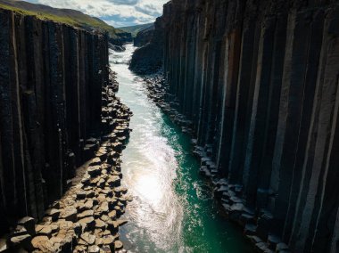 Görkemli turkuaz nehir, eşsiz beyaz kaya oluşumlarından geçiyor, tam havadan çekimin üstünde. Kanyon, vadi, doğa ve İzlanda konsepti.