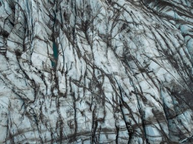 Koyu gri volkanik kaya oluşumu serinletilmiş lavdan oluşmuş, yukarıdan aşağıya doğru havadan çekilmiş. Doğa arka planı, doku ve şablon kavramları.