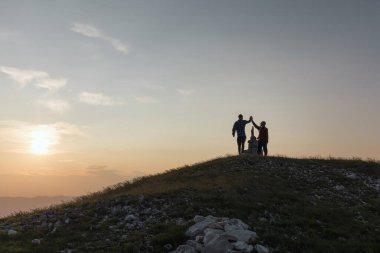 Gençlik yürüyüşü macerası, neşeli bir genç kız ve genç bir oğlan dağın zirvesinde beşlik çakıyor, başarının tadını çıkarıyorlar. Eğlence, ilham ve eğlence kavramları..