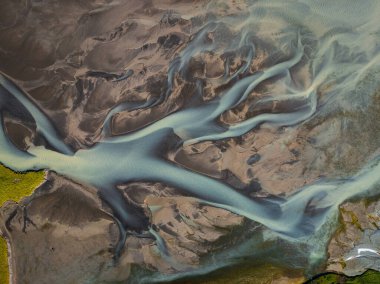 İzlanda nehirlerinin desenlerinin ve renklerinin soyutlanması, buzul eritilmiş su, alüvyon ve minerallerin karışımı, havadan çekim. Arkaplan ve tasarım kavramları.