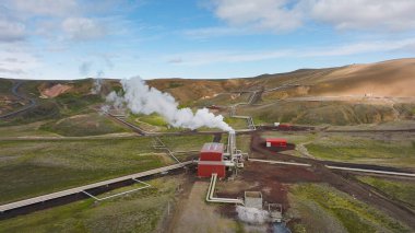İzlanda 'daki jeotermal enerji santrali, güneşli bir günde vadide bacaları buharlaştırmak, hava manzarası. Enerji, endüstri ve sürdürülebilirlik kavramı.