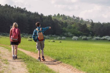 Genç bir kız ve genç bir oğlan bahar tatilinde doğa yürüyüşü yaparak zaman geçiriyorlar. Sağlıklı aktivite ve aile zaman kavramları.