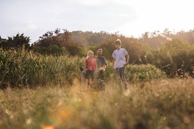 Engelli bir baba ve çocukları kırsal alanlarda rahatça dolaşır ve birbirlerine eşlik ederler. Aile kavramı.