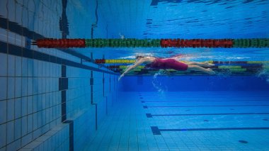 Suya daldırma evresinde kadın yüzücü, su yüzeyinin altında kayıyor, sualtı çekimi. Su sporları konsepti.
