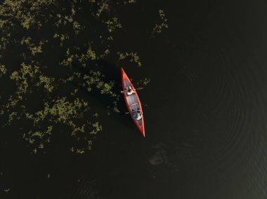 Sakin gölde yüzen kanolar, görkemli doğal çevrenin ve alacakaranlık ışınlarının tadını çıkarıyorlar. Huzur ve sessizlik.