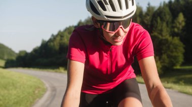 Woman road cycling on race bike outdoor in nature