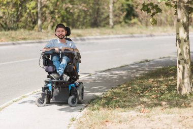 Fiziksel engelli bir adam, güneşli bir sonbahar gününde sokaklarda tekerlekli sandalye kullanan bir adam. Bağımsız yaşam kavramı.