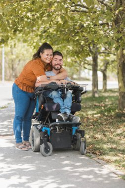 Şefkat anı, fiziksel bir engelle kocasını öpen ve kucaklayan bir kadın. Çeşitlilik, aşk ve ilişki kavramları.