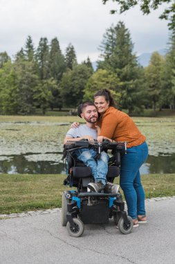 Göl kıyısında kucaklaşan bir çift, engelli bir adam kız arkadaşının şefkatli kollarında. Aşk ve ilişki kavramı.