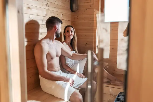 stock image Young couple enjoying a serene moment, a rejuvenating healthy treatment in the sauna. Relaxation and well-being concepts.