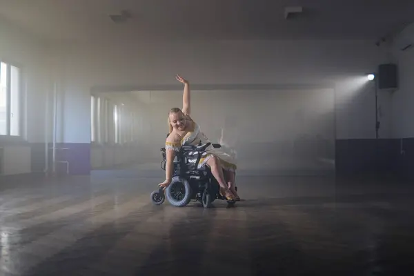 stock image Woman practicing and performing a freestyle wheelchair dance at a dancing studio, wide shot. Para dance sport concept.