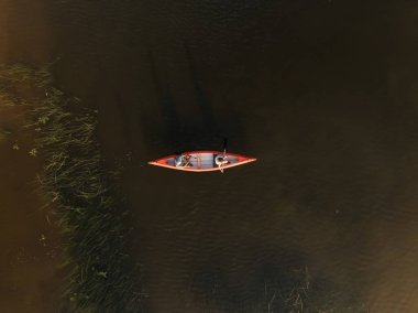 Aktif bir çift, güzel dağ gölünde kanoyla gezintiye çıkıyor, göl kıyısında tatilin tadını çıkarıyor, havadan çekim yapıyor..