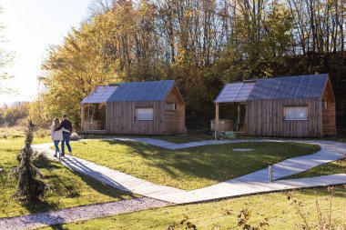 Sevgi dolu bir çift glamping merkezinde yürüyor, doğanın tadını çıkarıyor ve günlük hayattan kaçıyor. Turizm ve seyahat kavramı.