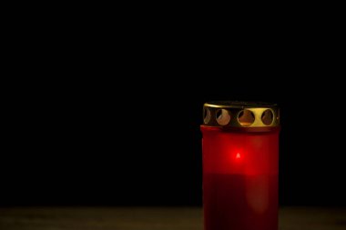 Red cemetery candle, on a black background, close up shot. All saints day concept. clipart