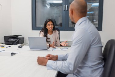 Ofiste iş görüşmesi, Hintli bir bayan yönetici motive olmuş bir Afrikalı Amerikalı erkek adayla konuşuyor..