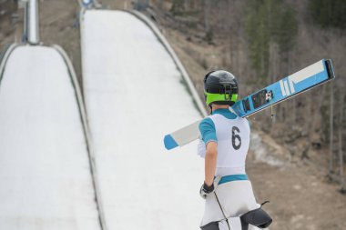 Young ski jumpers training on a ski jumping hill on snow in winter clipart