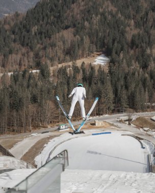 Flight moment of a ski jumper over the snow hill, skier in the air. Soaring through the sky concept. clipart