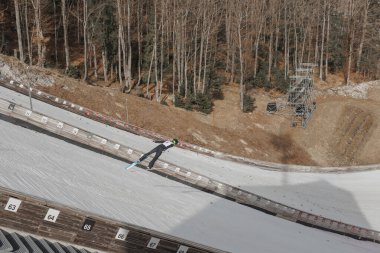 Ski jumper taking flight at the ski center Planica in Slovenia, performing winter sport highlight speed and skill. clipart