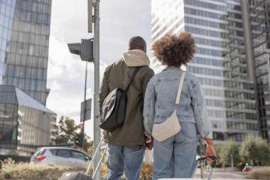 Afrika kökenli Amerikalı bir çift Avrupa 'da tatilde. Tekerlekli bavullu turistler kalabalık bir caddeden geçip şehir oteline gidiyorlar..