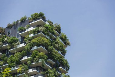 Residential tower, an example of modern architecture with various plants and tree-covered balconies. Sustainability and tree skyscraper concept. clipart