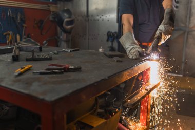 Bir atölyede öğütücü kullanan metal işçisi, küçük bir ev işletmesinde üretim ve onarım yapıyor..