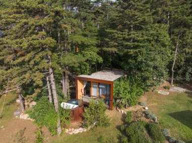 Tahta güverteli ve ormanda jakuzili göz alıcı bir kulübe. İHA atışı