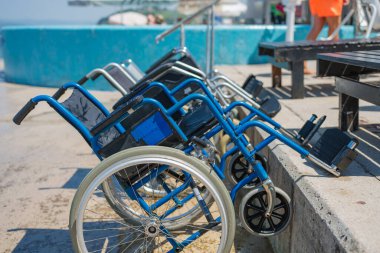 Boş tekerlekli sandalyeler, ulaşılabilir yüzme havuzu ve plaj ekipmanları, yaz tatilinde engelliler için taşınabilirlik yardımı.