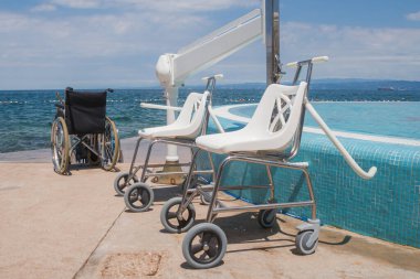 Boş tekerlekli sandalyeler, ulaşılabilir yüzme havuzu ve plaj ekipmanları, yaz tatilinde engelliler için taşınabilirlik yardımı.
