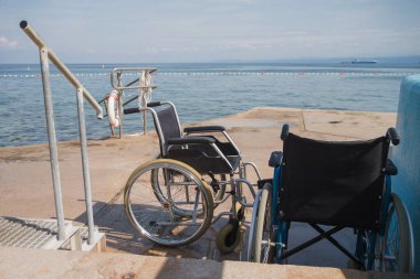 Boş tekerlekli sandalyeler, ulaşılabilir yüzme havuzu ve plaj ekipmanları, yaz tatilinde engelliler için taşınabilirlik yardımı.