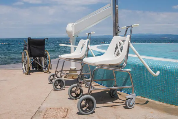 Boş tekerlekli sandalyeler, ulaşılabilir yüzme havuzu ve plaj ekipmanları, yaz tatilinde engelliler için taşınabilirlik yardımı.