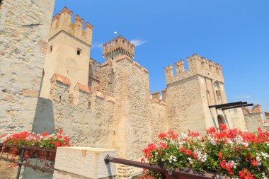 Sirmione 'deki ortaçağ şatosunun tarihsel çekiciliğini keşfedin. Canlı çiçekler ve güneşli bir günde Garda Gölü' nün dingin güzelliği..