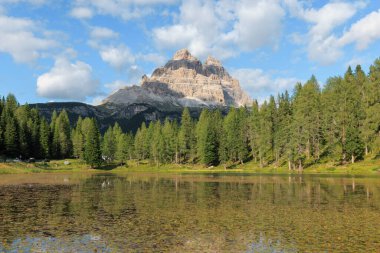Ziyaretçiler, görkemli Dolomitlerle çevrili Antorno Gölü 'nün huzurlu atmosferinin tadını çıkarıyorlar. Berrak gökyüzü suyu yansıtırken, yemyeşil ağaçlar manzarayı çerçeveler..