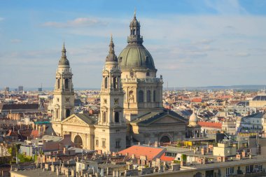 Macaristan 'ın Budapeşte kentinde nefes kesen St. Stephens Bazilikası şehrin siluetine karşı dimdik ayakta duruyor. Bu ikonik simge şehir çatıları arasında zarif mimari detaylar sergiliyor..