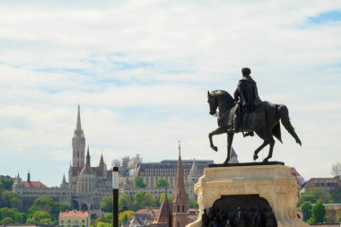 Arka planda çarpıcı mimari simgeler ve yeşillikle Budapeşte 'de belirgin bir binicilik heykeli bulunuyor. Bu sahne Macaristan 'ın zengin tarihinin özünü yansıtıyor..